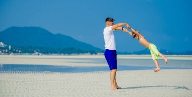 Baba ve oğul çöl güneşli kumsalda eğleniyor