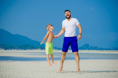 Baba ve oğul çöl güneşli kumsalda eğleniyor