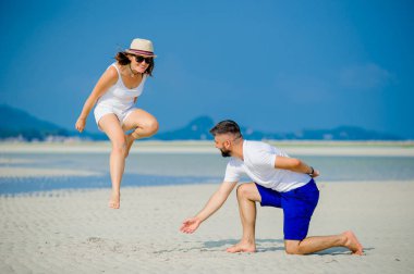 Mutlu genç çift çöl güneşli kumsalda eğleniyor