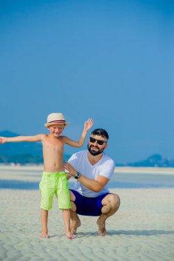 Baba ve oğul çöl güneşli kumsalda eğleniyor