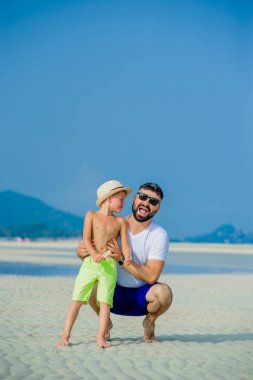 Baba ve oğul çöl güneşli kumsalda eğleniyor