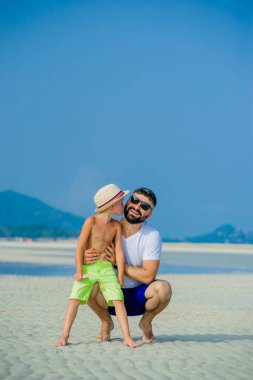 Baba ve oğul çöl güneşli kumsalda eğleniyor