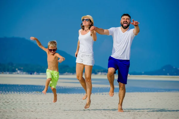 Üç çöl güneşli kumsalda eğleniyor mutlu genç aile