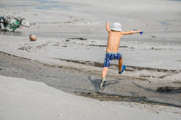 Zeven jaar oude jongen springen over het riviertje — Stockfoto