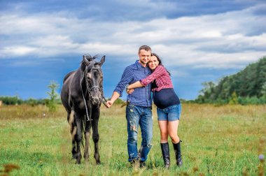 Çayır üzerinde yürüyen çocuk bekliyor. Genç çift - bir kız