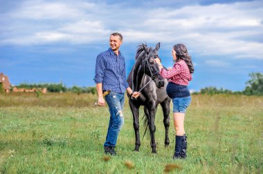 Çayır üzerinde yürüyen çocuk bekliyor. Genç çift - bir kız