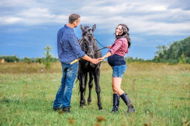 Çayır üzerinde yürüyen çocuk bekliyor. Genç çift - bir kız