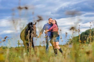 Çimlere bakın: genç çift - güzel bir esmer. 