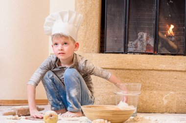 Şef şapkaları mutfak f üzerinde oturan şömine yakın içinde bir oğlan