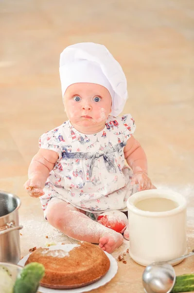 Şef'in şapkalı mutfak kat topraklarında oturan sevimli liitle kız