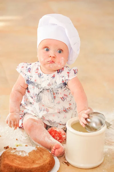 Şef'in şapkalı mutfak kat topraklarında oturan sevimli liitle kız