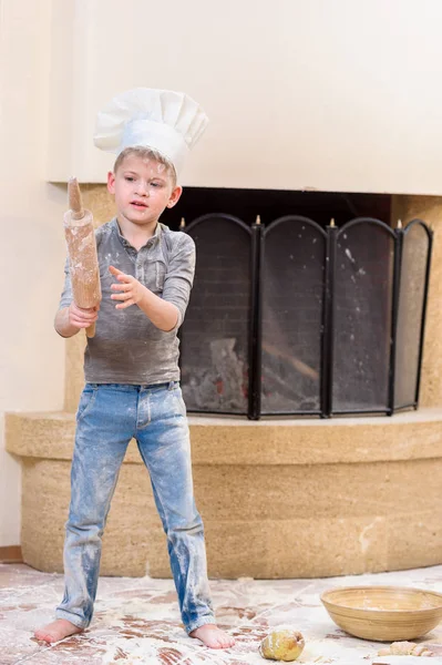 Şef şapkaları şömine ayakta mutfak yakınındaki bir çocuk 