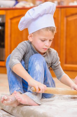 İki kardeş - erkek ve kız - kitc üzerinde oturan şefin şapka içinde