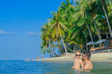 Aile portresi: baba ve oğul su bir Dönencesi üzerinde oturan