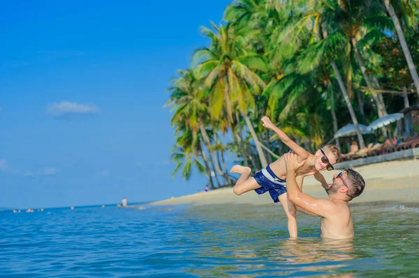 Retrato de felicidad en agua tropical: padre barbudo lanza su —  Fotos de Stock