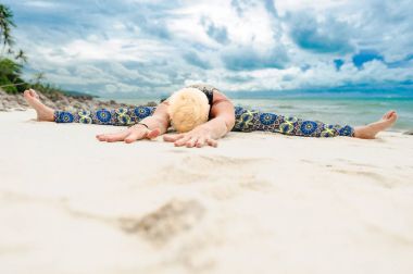 Güzel olgun yaşlı kadın bir ıssız tropikal beac Yoga yapıyor