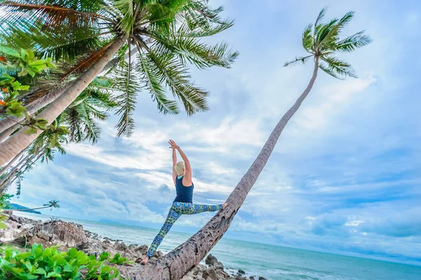 Güzel olgun yaşlı kadın bir ıssız tropikal beac Yoga yapıyor
