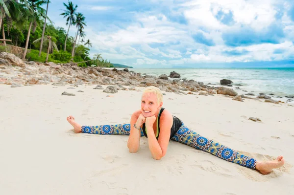 Güzel olgun yaşlı kadın bir ıssız tropikal beac Yoga yapıyor