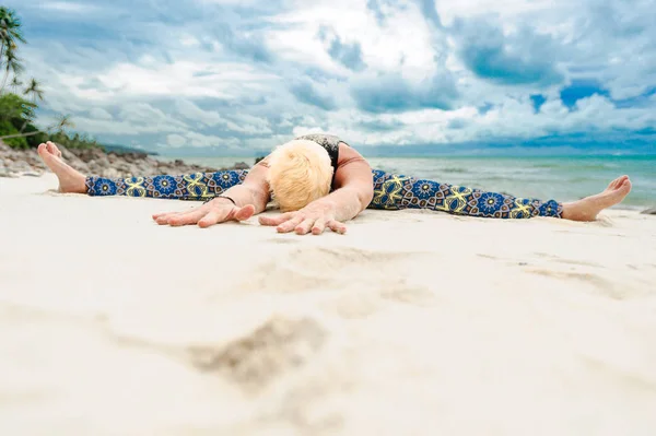 Güzel olgun yaşlı kadın bir ıssız tropikal beac Yoga yapıyor — Stok fotoğraf