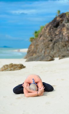 Güzel olgun yaşlı kadın bir ıssız tropikal beac Yoga yapıyor