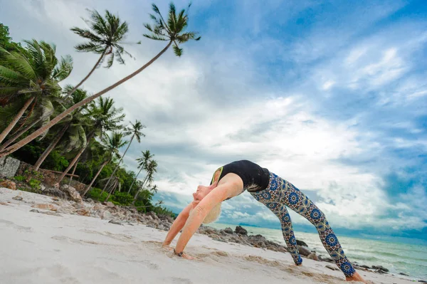 Güzel olgun yaşlı kadın bir ıssız tropikal beac Yoga yapıyor