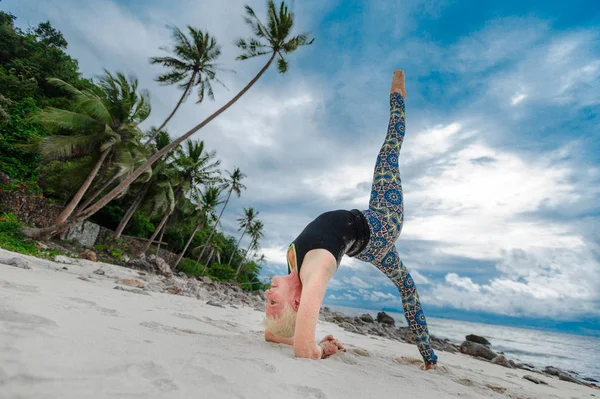 Güzel olgun yaşlı kadın bir ıssız tropikal beac Yoga yapıyor
