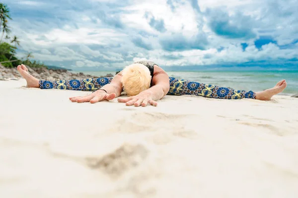 Mooie rijpe leeftijd vrouw doet yoga op een woestijn tropisch beac — Stockfoto