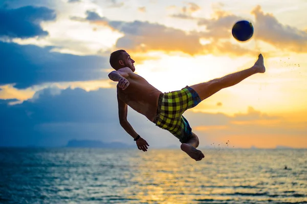 Patear una pelota. Silueta de un hombre en una playa — Foto de Stock