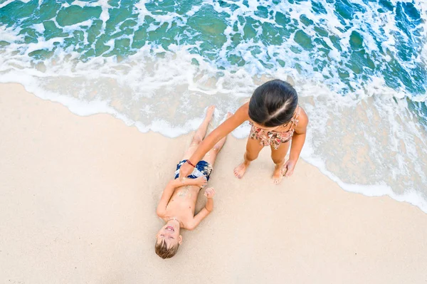 Dos niños divirtiéndose en la soleada playa tropical —  Fotos de Stock