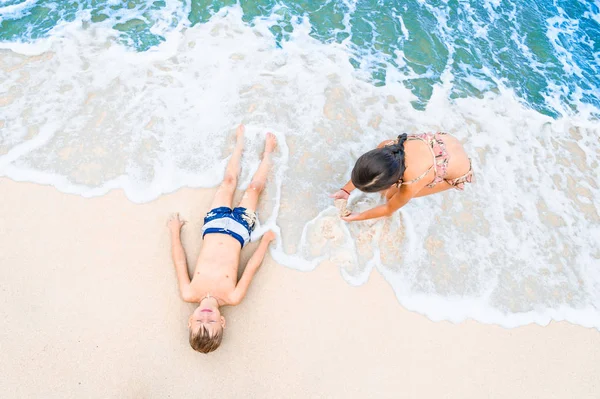 Due bambini si divertono sulla soleggiata spiaggia tropicale — Foto Stock