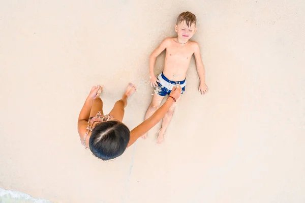 Due bambini si divertono sulla soleggiata spiaggia tropicale — Foto Stock