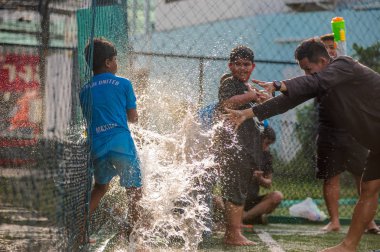 Koh Samui, Tayland - 12 Nisan 2018: Songkran futbol partisi - Tay Yeni yıl festivalde bir futbol sahası. Çocuklar, veliler ve antrenörler birlikte kutluyor. Su silah ve eğlenceli
