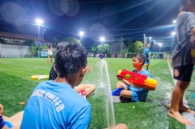 Koh Samui, Tayland - 12 Nisan 2018: Songkran futbol partisi - Tay Yeni yıl festivalde bir futbol sahası. Çocuklar, veliler ve antrenörler birlikte kutluyor. Waterguns ve eğlenceli. Bulanık hareket.