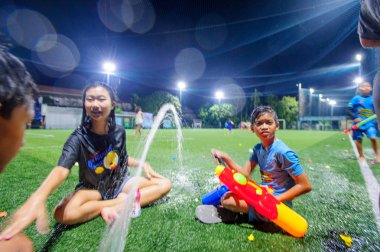Koh Samui, Tayland - 12 Nisan 2018: Songkran futbol partisi - Tay Yeni yıl festivalde bir futbol sahası. Çocuklar, veliler ve antrenörler birlikte kutluyor. Waterguns ve eğlenceli. Bulanık hareket.