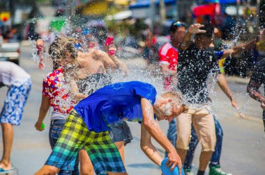 Taylandlılar ve turistler su tabancası kullanıyor, birbirlerine su döküyorlar, Songkran festivalinde eğleniyorlar, geleneksel Tayland Yeni Yılı.