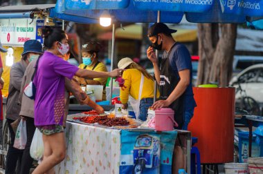 Koh Samui, Tayland - 30 Mart 2020: Covid-19 ile ilişkili tehlikelere rağmen sokak satıcıları çalışmaya devam ediyor. Önlemler alınıyor: satıcıların ve müşterilerinin maskeleri, raflarda el dezenfektanı