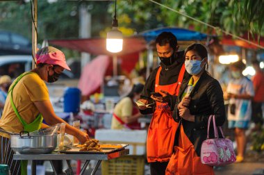 Koh Samui, Tayland - 30 Mart 2020: Covid-19 ile ilişkili tehlikelere rağmen sokak satıcıları çalışmaya devam ediyor. Önlemler alınıyor: satıcıların ve müşterilerinin maskeleri, raflarda el dezenfektanı