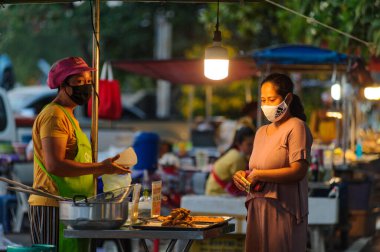 Koh Samui, Tayland - 30 Mart 2020: Covid-19 ile ilişkili tehlikelere rağmen sokak satıcıları çalışmaya devam ediyor. Önlemler alınıyor: satıcıların ve müşterilerinin maskeleri, raflarda el dezenfektanı