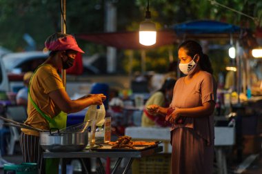 Koh Samui, Tayland - 30 Mart 2020: Covid-19 ile ilişkili tehlikelere rağmen sokak satıcıları çalışmaya devam ediyor. Önlemler alınıyor: satıcıların ve müşterilerinin maskeleri, raflarda el dezenfektanı