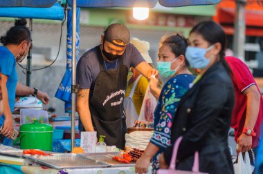 Koh Samui, Tayland - 30 Mart 2020: Covid-19 ile ilişkili tehlikelere rağmen sokak satıcıları çalışmaya devam ediyor. Önlemler alınıyor: satıcıların ve müşterilerinin maskeleri, raflarda el dezenfektanı