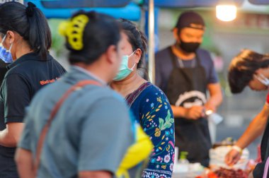 Koh Samui, Tayland - 30 Mart 2020: Covid-19 ile ilişkili tehlikelere rağmen sokak satıcıları çalışmaya devam ediyor. Önlemler alınıyor: satıcıların ve müşterilerinin maskeleri, raflarda el dezenfektanı