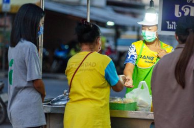 Koh Samui, Tayland - 30 Mart 2020: Covid-19 ile ilişkili tehlikelere rağmen sokak satıcıları çalışmaya devam ediyor. Önlemler alınıyor: satıcıların ve müşterilerinin maskeleri, raflarda el dezenfektanı