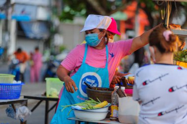 Koh Samui, Tayland - 30 Mart 2020: Covid-19 ile ilişkili tehlikelere rağmen sokak satıcıları çalışmaya devam ediyor. Önlemler alınıyor: satıcıların ve müşterilerinin maskeleri, raflarda el dezenfektanı