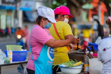 Koh Samui, Tayland - 30 Mart 2020: Covid-19 ile ilişkili tehlikelere rağmen sokak satıcıları çalışmaya devam ediyor. Önlemler alınıyor: satıcıların ve müşterilerinin maskeleri, raflarda el dezenfektanı