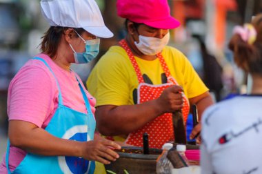 Koh Samui, Tayland - 30 Mart 2020: Covid-19 ile ilişkili tehlikelere rağmen sokak satıcıları çalışmaya devam ediyor. Önlemler alınıyor: satıcıların ve müşterilerinin maskeleri, raflarda el dezenfektanı