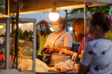 Koh Samui, Tayland - 30 Mart 2020: Covid-19 ile ilişkili tehlikelere rağmen sokak satıcıları çalışmaya devam ediyor. Önlemler alınıyor: satıcıların ve müşterilerinin maskeleri, raflarda el dezenfektanı