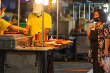 Koh Samui, Tayland - 30 Mart 2020: Covid-19 ile ilişkili tehlikelere rağmen sokak satıcıları çalışmaya devam ediyor. Önlemler alınıyor: satıcıların ve müşterilerinin maskeleri, raflarda el dezenfektanı