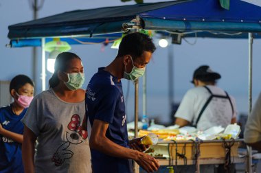 Koh Samui, Tayland - 30 Mart 2020: Covid-19 ile ilişkili tehlikelere rağmen sokak satıcıları çalışmaya devam ediyor. Önlemler alınıyor: satıcıların ve müşterilerinin maskeleri, raflarda el dezenfektanı.