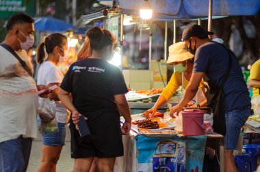 Koh Samui, Tayland - 30 Mart 2020: Covid-19 ile ilişkili tehlikelere rağmen sokak satıcıları çalışmaya devam ediyor. Önlemler alınıyor: satıcıların ve müşterilerinin maskeleri, raflarda el dezenfektanı.