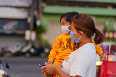 Koh Samui, Tayland - 30 Mart 2020: Küçük çocuk ve annesi yiyecek bulmak için yerel bir markete geldiler. Her ikisi de Coronavirus COVID-19 'un yayılmasını önlemek için maske takıyor..